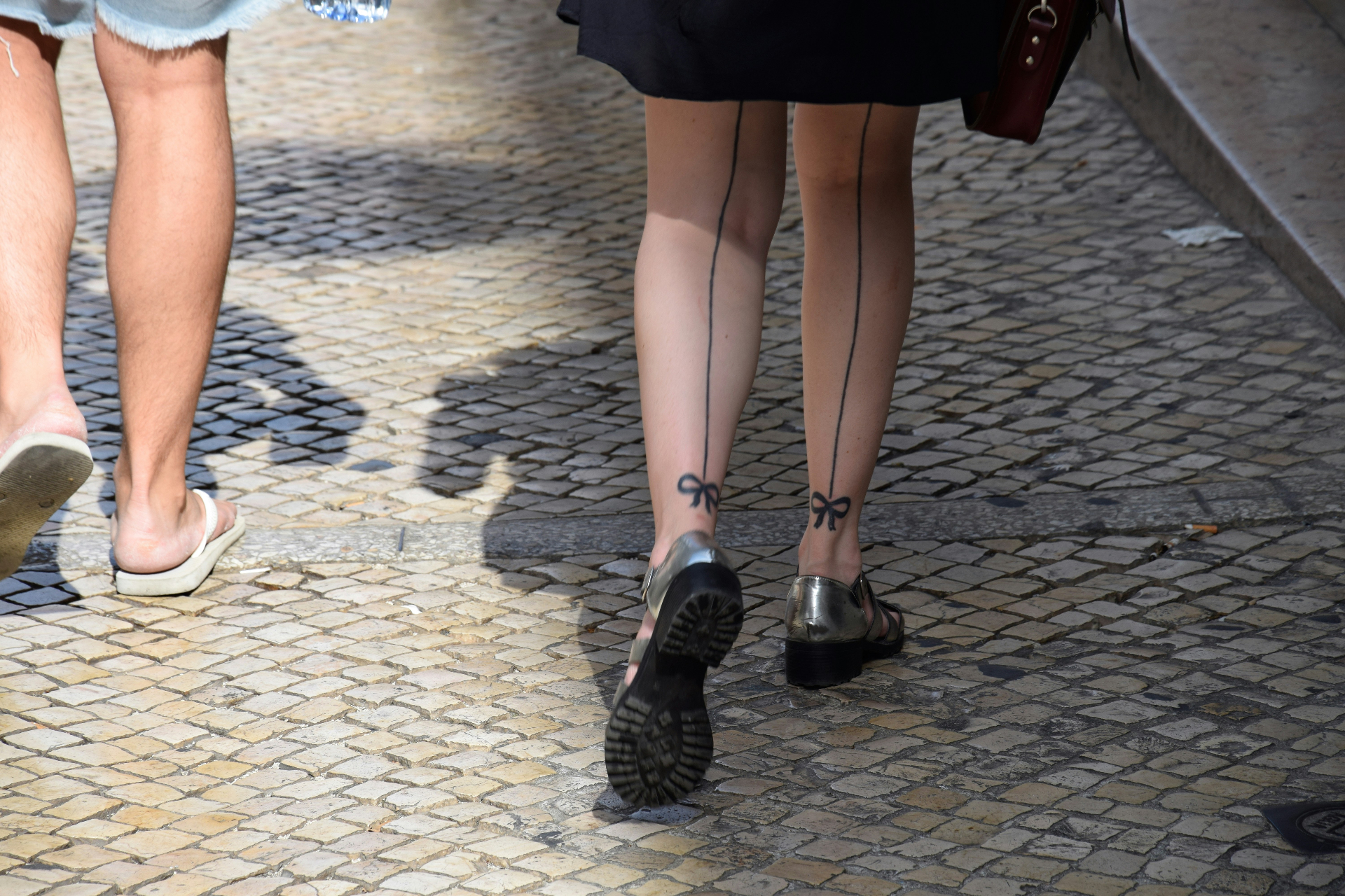 Legs walking on cobblestone street wearing compression tights